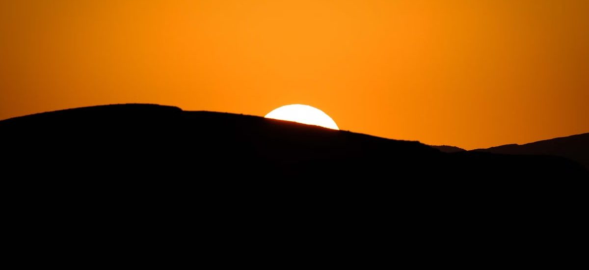 Stunning silhouette of a mountain ridge during a vibrant sunset with a glowing sky.