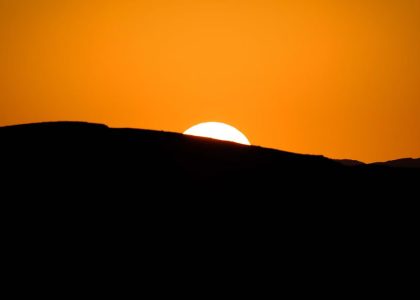 Stunning silhouette of a mountain ridge during a vibrant sunset with a glowing sky.